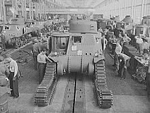 photographie en noir et blanc montrant des ouvriers en train d’installer les chenilles sur un char en construction