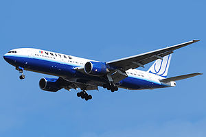 Aircraft landing approach. Front quarter view of twin-engine jet in flight with flaps and landing gear extended.