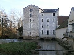 Vue d'un bâtiment à plusieurs étages établi au-dessus d'un cours d'eau.