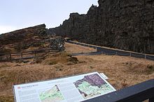 Ruine avec un panneau explicatif près d'une faille.