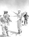 Luitenant Kolonel Robert Cassidy probeert Luitenant Kolonel Glover Johns tijdens de reeks Operatie "Tumbler-Snapper" in 1952 met een bezem van het radioactieve stof te ontdoen. ´Zij hadden zojuist een "hete", eufemisme voor radioactieve, ground zero bezocht.