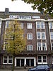 Pand, deel uitmakend van een huizenblok, in een trant die met zijn hoekige en stekelige detaillering het begin van de 'Amsterdamse School' aankondigt