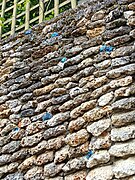 Détail d'un mur de meulière et de ses éclats de silex et lapis-lazulis