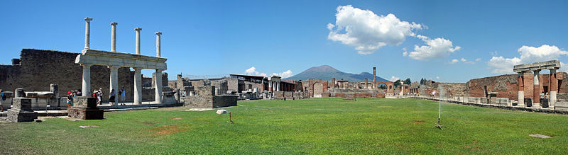 O Foro de Pompeia coas entradas á Basílica (esquerda) e Macellum (dereita), o Templo de Xúpiter (fronte) e Monte Vesuvio na distancia.