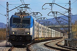 La locomotora elèctrica 253-102 de COMSA Rail Transport arrossega el fruiter al seu pas per Figueres.