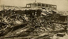 A group of people stand amongst rubble