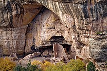 Imagen en color de una gran vivienda de piedra arenisca en un acantilado