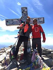 Alpinistes devant la croix de l'Aneto, au sommet du pic.