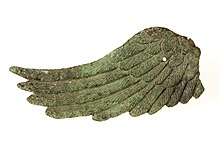 Photographie de l'aile droite d'une statuette de Victoire, de couleur verte. On distingue les plumes.