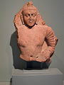 Fragment : Bouddha (probablement debout). Région de Mathura. V. 100-200. Grès rose tacheté, H. 51,44 cm x P. 11,8 cm. AAM, San Francisco[8]