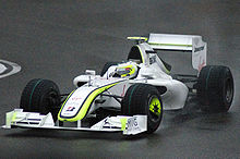 Photo de la BGP 001 de Barrichello sortant d'un virage, sous la pluie, avec des pneus pluie