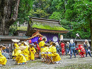 右側の青と赤の衣装の者は棒振りの演舞を行っている。