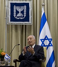 נשיאה ה-9 של המדינה, שמעון פרס, עם דגל ישראל ונס הנשיא