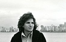 Determined-looking young man against city skyline.