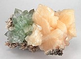 Clustered on a matrix of white chalcedony are a group of light salmon stilbite crystals; adjoining is a cluster of mint green fluorapophyllite crystals
