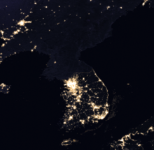 Photographie satellite de la péninsule coréenne de nuit, seul le sud présente des points éclairés.