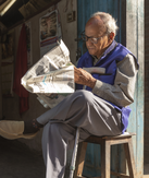 Photo of a man reading a newspaper