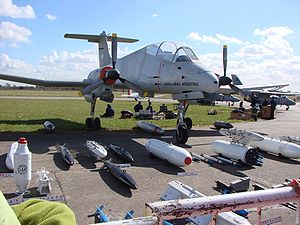 Pucará s prezentací výběru možné podvěsné výzbroje. Podle „01“ na krytu předního podvozku by se mělo jednat o A-501 – první sériově vyrobený stroj. A-501 byla přijata do služby v listopadu 1974, během války o Falklandy byla umístěna na BAM Santa Cruz a vyřazena 1987. Následně používána v Escuela de Suboficiales de la Fueza Aéra k pozemnímu výcviku[1]