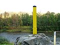 Grensemerke 367. Gul stolpe med sort topp markerer norsk side, rød og grønn stolpe markerer russisk side. Grensen går i elven på det dypeste punktet mellom disse stolpene.