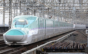 Teal and white bullet train with purple stripe