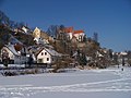Monasterio y casas al lado del río en invierno