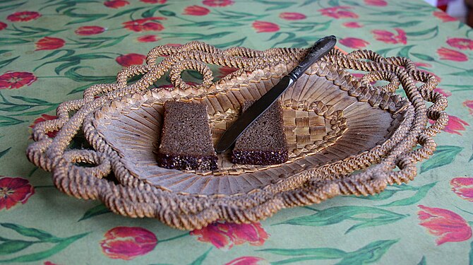 Two slices of black bread on a straw tray