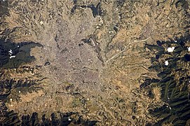 The green, vegetated slopes that surround the Kathmandu metro area (light grey, image centre) include both forest reserves and national parks