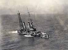 A sinking stripped battleship seen from a birds eyes view