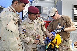US Navy Diver Ryan Oakley explains the inner workings of a Kirby Morgan 37 diving helmet to Iraqi sailors.jpg