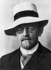 Photographie en gros plan et en noir et plan de David Hilbert, de trois quarts face, portant un chapeau.