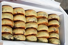 24 buns in golden brown are put in a white rectangular box. The buns are arranged like an abacus.