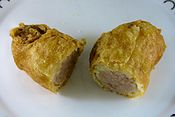 A battered sausage, sliced in half after cooking