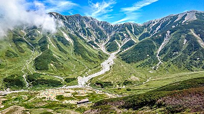 雷鳥荘付近から見た、立山連峰の別山（左）、真砂岳（右）とカラフルなテントが立つ雷鳥沢キャンプ場（左下）