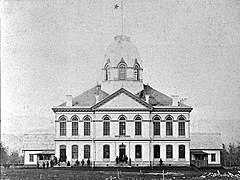 Photo en noir et blanc d'un bâtiment de deux étages surmonté d'une imposante coupole.