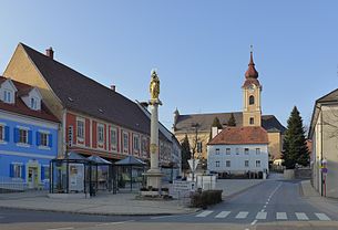 Ilz, Hauptplatz mit Mariensäule Pfarrhof und Pfarrkirche im Hintergrund