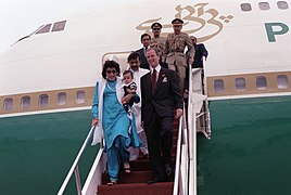 Benazir Bhutto, the Prime Minister of Pakistan, carries a child as she leads her official party off of an airliner upon her arrival for a state visit - DPLA - f16da39cdc04032c358bda73933ea16e.jpeg