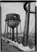 DETAIL OF WATER TOWERS IN PROCESS OF BEING DEMOLISHED; FERRY BUILDING IS VISIBLE THROUGH SUPPORTS OF TOWER ON LEFT - Ellis Island, Water Towers, New York Harbor, New York, New HABS NY,31-ELLIS,1H-1.tif