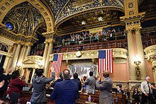 Legislators cheer and acknowledge nurses in upper gallery