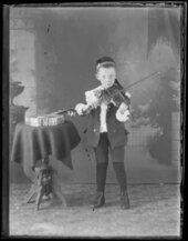 Un "joven tocando el violín". A su lado hay una mesa en la que probablemente haya un banjo.