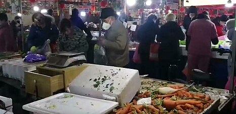 Residents de Wuhan amb màscares comprant al mercat. 23 de gener de 2020