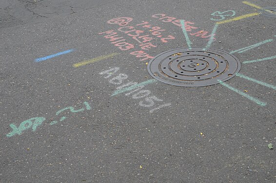 A manhole cover with construction markings surrounding it in Portland, Oregon