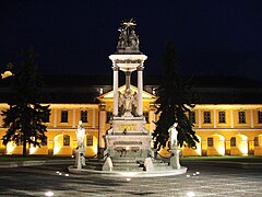 Estatua de la Santísima Trinidad en la plaza Széchenyi con la casa de János Bottyán en el fondo.