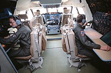 Cockpit d'un C-5. Au centre de l'image, deux pilotes. Il y a 5 autres postes.