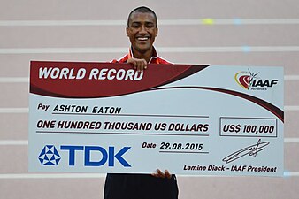 Ashton Eaton mostra o cheque de 100.000 dólares que ganhou pelo recorde mundial do decatlo.