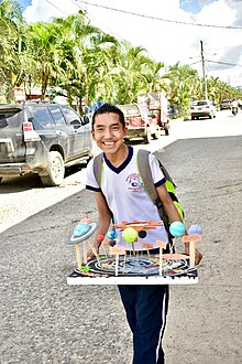 A boy holding a three-dimensional display of the planets in the Solar System