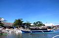 Cantilan Harbour, sight from the river. Buildings on shore: left the market hall, right the Fire watch building