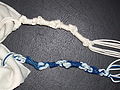 Dos tzitzit, unu blancu y otru con hebras azules.