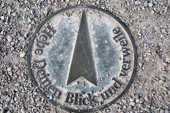 A manhole cover with a philosophical slogan by the river Ilm