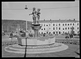 Per Hurums skulptur «De tre bydeler» ble oppført på Strømsø torg ved Drammen stasjon i 1952. Foto: Nasjonalbibliotekets bildesamling