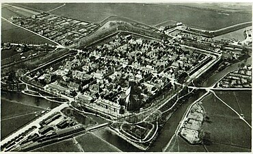 Luchtfoto van Elburg tussen 1908 en 1931 met op de voorgrond de remise van de Zuiderzeetram.